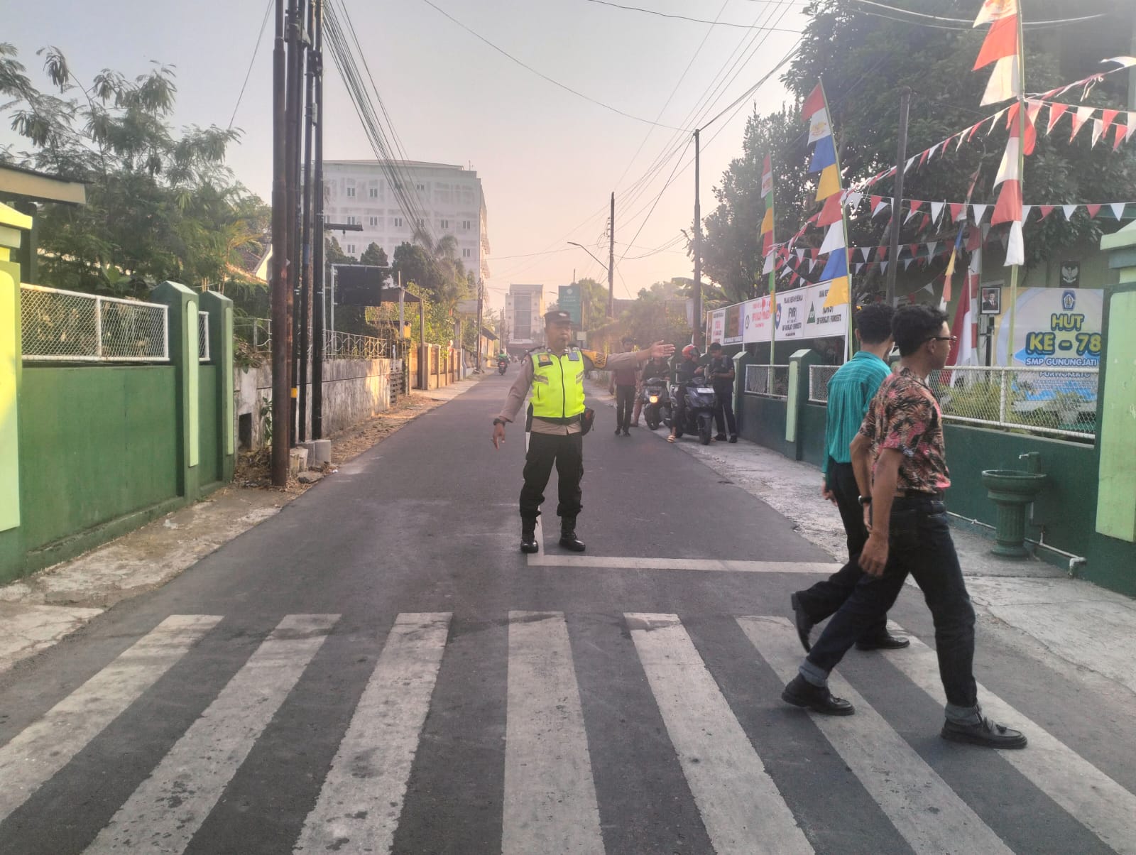 Yanmas Pagi, Bhabinkamtibmas Polsek Purwokerto Barat Bantu Pelajar Menyeberang di Depan Sekolah